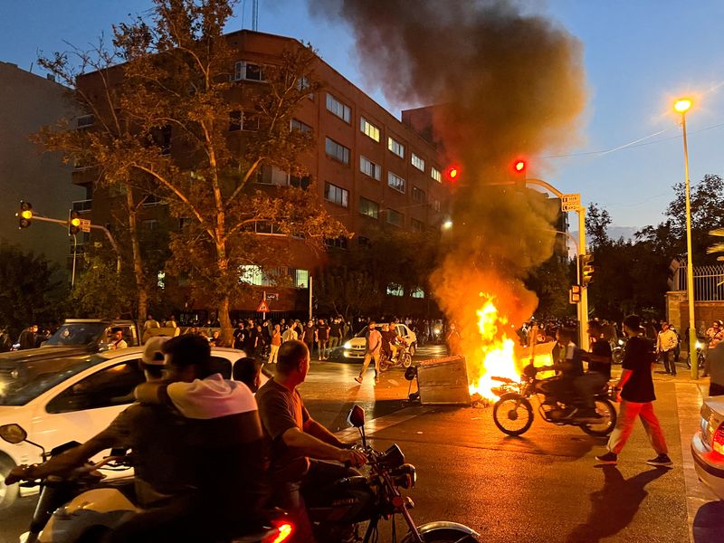 © Reuters. دراجة نارية تابعة للشرطة تحترق خلال مظاهرات في طهران يوم 19 سبتمبر ايلول 2022. صورة من وكالة غرب آسيا للأنباء. 