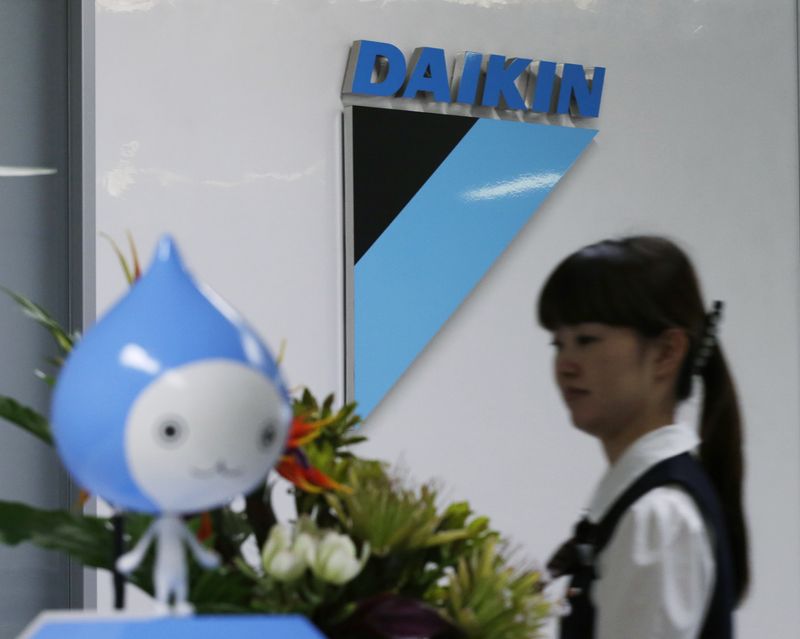 &copy; Reuters. FILE PHOTO: A staff walks past a logo of Daikin Industries Ltd and the company mascot "Pichon" at the company's office in Tokyo August 29, 2012. REUTERS/Toru Hanai 