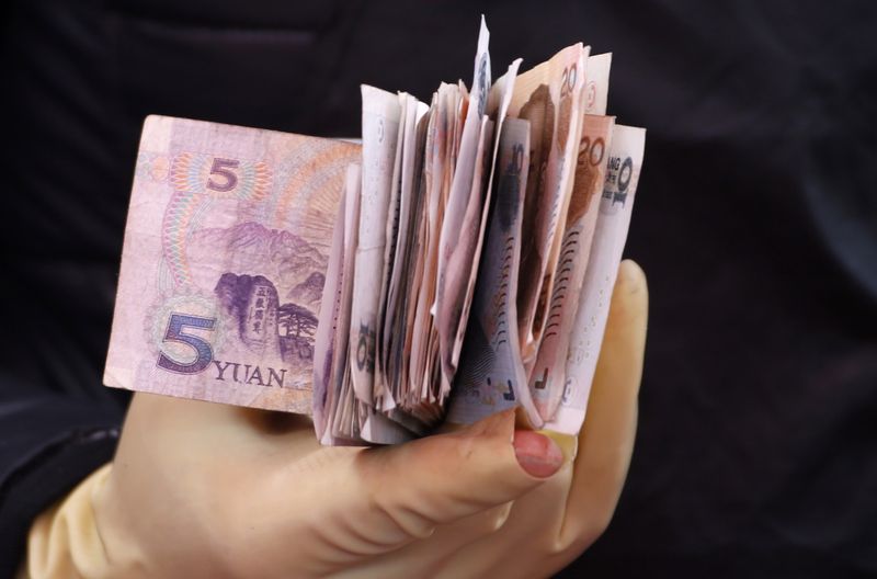 &copy; Reuters. FILE PHOTO: Chinese Yuan bank notes are seen in a vendor's hand at a market in Beijing April 10, 2013. REUTERS/Kim Kyung-Hoon 