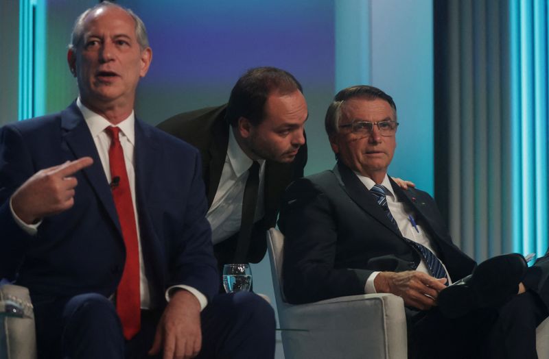 &copy; Reuters. Presidente Jair Bolsonaro conversa com o filho Carlos, ao lado do candidato Ciro Gomes, antes do início do debate entre os presidenciáveis na TV Globo
29/09/2022
REUTERS/Ricardo Moraes