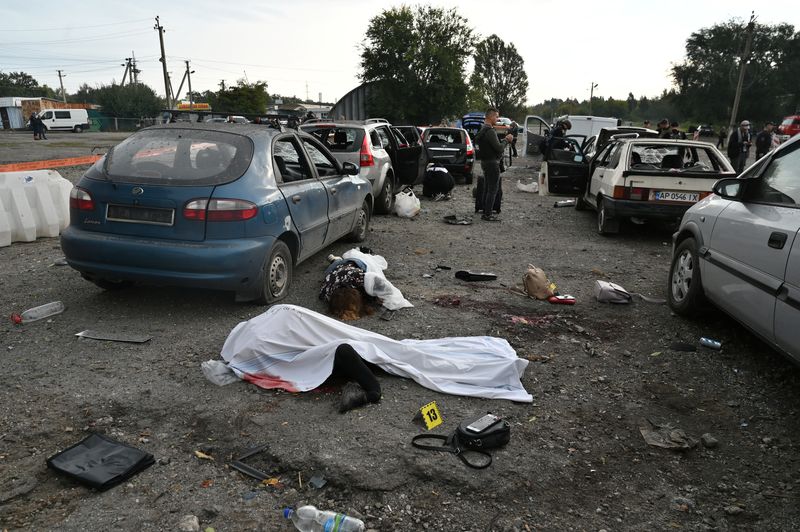 © Reuters. جثث أشخاص لقوا حتفهم في هجوم صاروخي روسي استهدف موكب سيارات مدنية في منطقة زابوريجيا بأوكرانيا يوم الجمعة في صورة لرويترز.