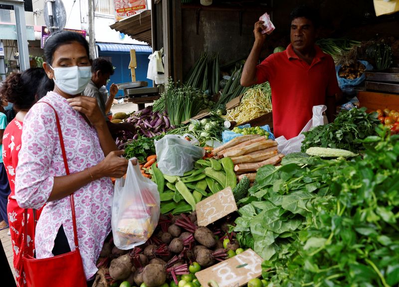 &copy; Reuters. FILE PHOTO: A vendor sells vegetables to a customer amid the rampant food inflation, amid Sri Lanka's economic crisis, in Colombo, Sri Lanka, July 29 , 2022. REUTERS/Kim Kyung-Hoon/File Photo