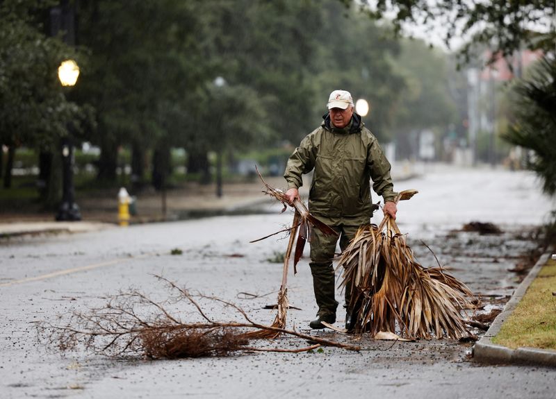 © Reuters. A local resident hauls debris from the road in an effort to keep gutter drains clear as hurricane Ian bears down on Charleston, South Carolina, U.S., September 30, 2022.  REUTERS/Jonathan Drake