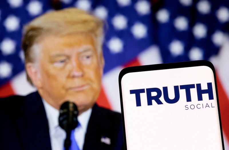 © Reuters. FILE PHOTO: The Truth social network logo is seen on a smartphone in front of a display of former U.S. President Donald Trump in this picture illustration taken February 21, 2022. REUTERS/Dado Ruvic/Illustration/File Photo