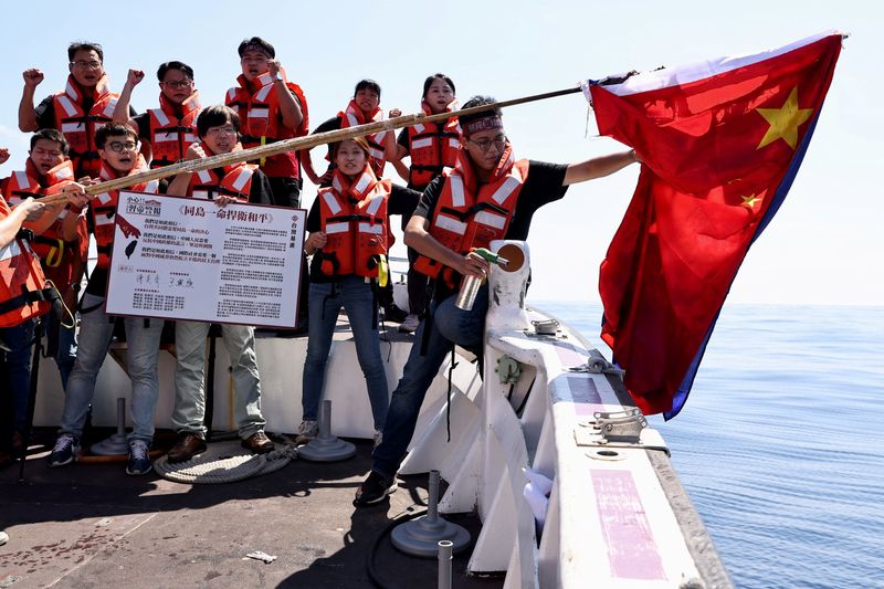 © Reuters. Members of the pro-independence Taiwan Statebuilding Party burn a Chinese flag on boat trip in the Taiwan Strait in Kaohsiung, Taiwan, October 1, 2022. REUTERS/Ann Wang