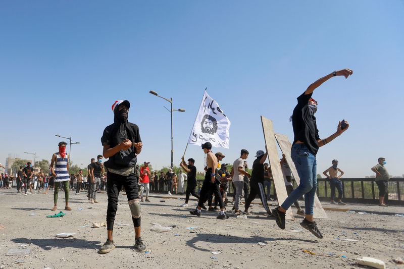 &copy; Reuters. متظاهرون عراقيون يلقون الحجارة خلال اشتباكات مع قوات الأمن يوم السبت في تجمع لإحياء الذكرى الثالثة للاحتجاجات المناهضة للحكومة في بغداد. ت