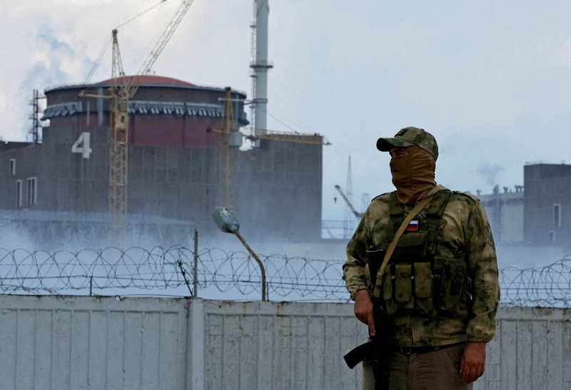 &copy; Reuters. FOTO DE ARQUIVO: Militar com uma bandeira russa em seu uniforme monta guarda perto da Usina Nuclear de Zaporizhzhia durante o conflito Ucrânia-Rússia na cidade de Enerhodar, controlada pela Rússia, na região de Zaporizhzhia, Ucrânia, 4 de agosto de 2