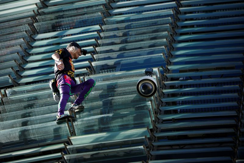 &copy; Reuters. O alpinista francês Alain Robert, também conhecido como "Homem-Aranha francês", escala o arranha-céu Torre Agbar para conscientizar sobre as mudanças climáticas globais em Barcelona, ​​​​Espanha. 1º de outubro de 2022. REUTERS/Albert Gea