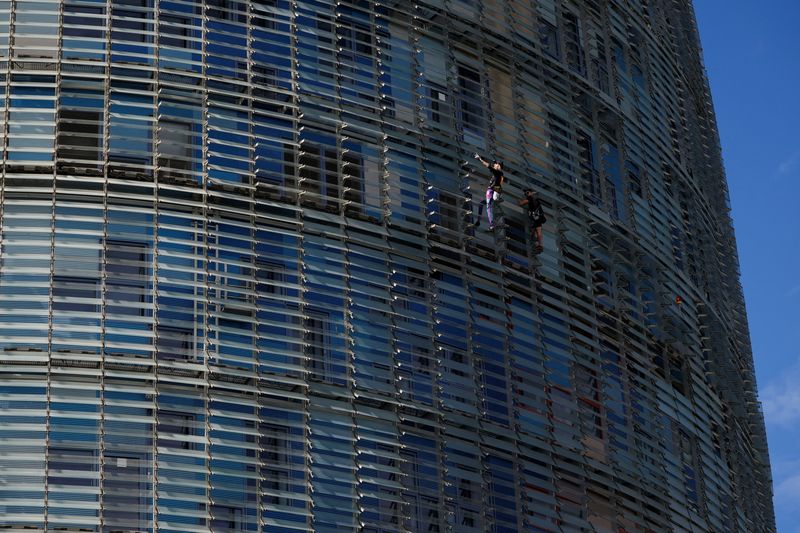 &copy; Reuters. "الرجل العنكبوت الفرنسي" ألان روبير يتسلق ناطحة سحاب ( برج أغبار) في برشلونة يوم السبت، مصطحبا معه ابنه جوليان. تصوير : ألبرت خيا - رويترز .   