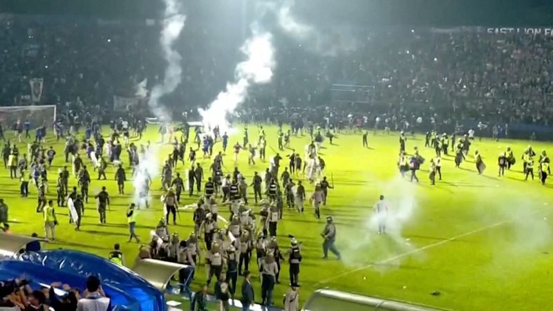 &copy; Reuters. Torcedores invadem o campo de futebol após uma partida entre Arema FC e Persebaya Surabaya no Estádio Kanjuruhan, Malang, Indonésia, em 2 de outubro de 2022 nesta captura de tela tirada de um vídeo da REUTERS. REUTERS TV via REUTERS