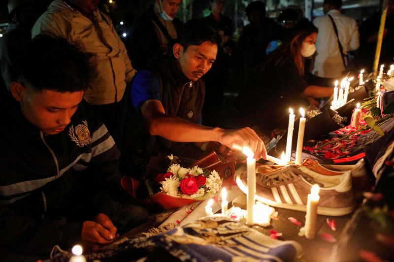 © Reuters. Arema football club supporters lights candles during a vigil outside the Kanjuruhan stadium to pay condolence to the victims, of a stampede following a soccer match between Arema vs Persebaya outside in Malang, East Java province, Indonesia, October 2, 2022. REUTERS/Willy Kurniawan