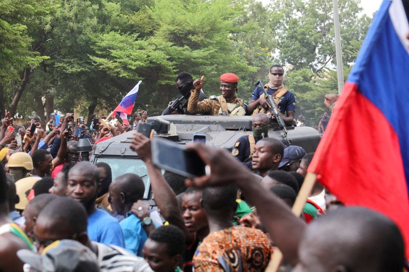 © Reuters. Burkina Faso's self-declared new leader Ibrahim Traore is welcomed by supporters holding Russian's flags as he arrives at the national television standing in an armoured vehicle in Ouagadougou, Burkina Faso October 2, 2022. REUTERS/Vincent Bado    