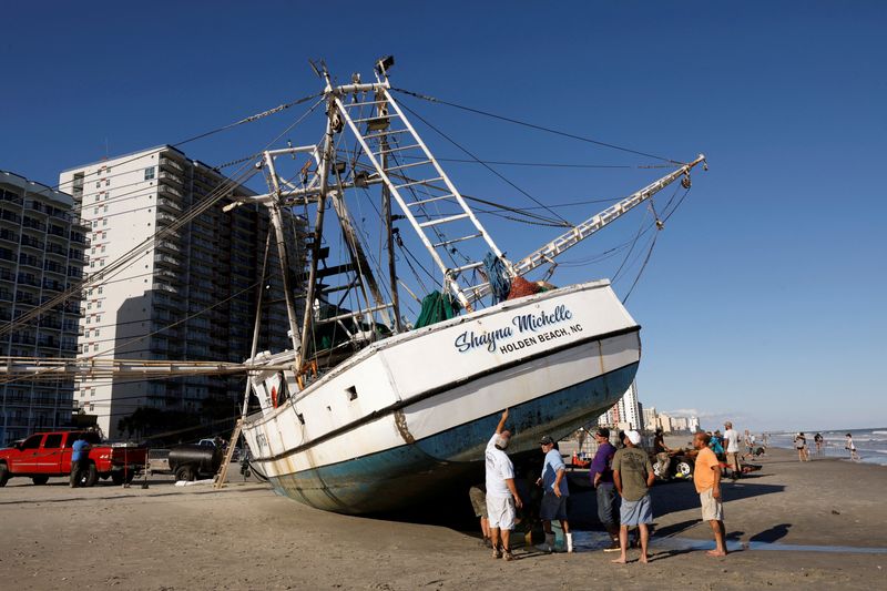 &copy; Reuters. Trabalhadores e proprietários de um grande barco de pesca de camarões preparam sua embarcação para voltar à água após ser varrida pela costa pelo furacão Ian em Myrtle Beach, Carolina do Sul, EUA, 1º de outubro de 2022. REUTERS/Jonathan Drake