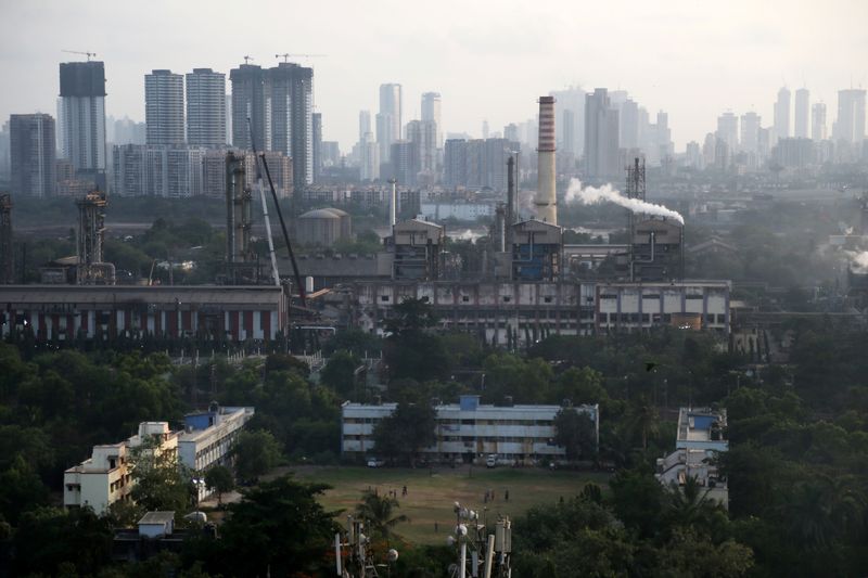 © Reuters. FILE PHOTO: Children play on a ground as smoke is emitted from chimneys of a Chemicals and Fertilizer plant on the eve of World Environment Day in Mumbai, India, June 4, 2019. REUTERS/Francis Mascarenhas