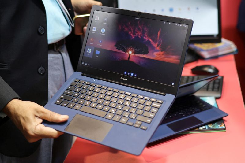 © Reuters. A man holds the Reliance's soon to be launched laptop called JioBook, kept on display at a stall of Jio at the ongoing India Mobile Congress 2022, at Pragati Maidan, in New Delhi, India, October 3, 2022. REUTERS/Anushree Fadnavis