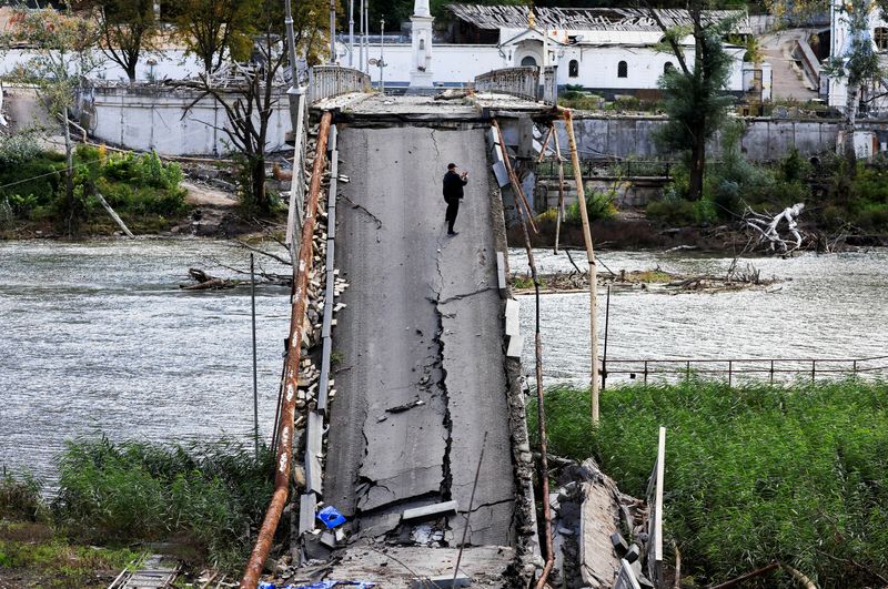 &copy; Reuters. Homem usa o celular em ponte destruída por míssil russo em Svyatohirsk, na Ucrânia. REUTERS/Zohra Bensemra