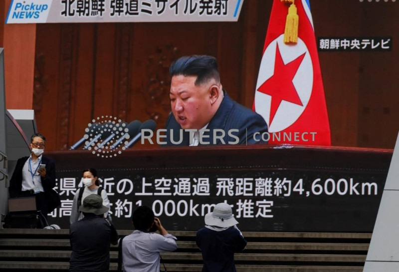 &copy; Reuters. Una serie di persone passa di fronrte ad uno schermo che trasmette notizie sul leader nordcoreano Kim Jong Un a Tokyo. 4 ottobre 2022 REUTERS/Issei Kato