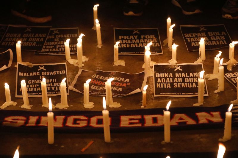 &copy; Reuters. Placards and candles are pictured during a vigil at Patriot Candrabhaga Stadium, after a riot and stampede at Kanjuruhan Stadium following a soccer match between Arema vs Persebaya Surabaya, in Bekasi, on the outskirts of Jakarta, Indonesia, October 3, 2
