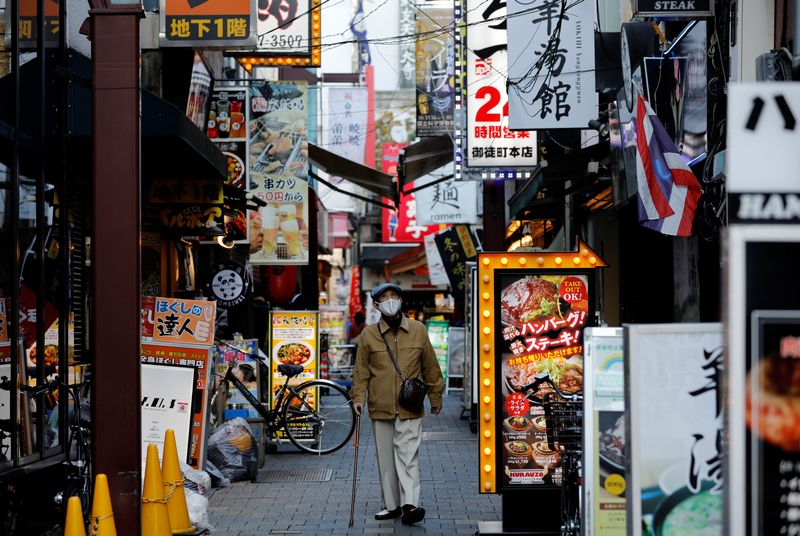 &copy; Reuters. FILE PHOTO: A man wearing a protective mask, amid the coronavirus disease (COVID-19) outbreak, makes his way at a restaurant district in Tokyo, Japan, December 1, 2021. REUTERS/Kim Kyung-Hoon