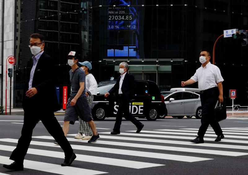 &copy; Reuters. أناس يمرون أمام شاشة إلكترونية تعرض حركة أسهم مؤشر نبكي الياباني داخل بناية تجارية في طوكبو يوم 22 سبتمبر أيلول 2022. تصويرك كيم كيونج-هون - روي