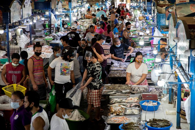 &copy; Reuters. FILE PHOTO: Vendors and customers wearing face masks for protection against the coronavirus disease (COVID-19) are seen inside a public market in Quezon City, Metro Manila, Philippines, February 5, 2021. REUTERS/Eloisa Lopez/File Photo
