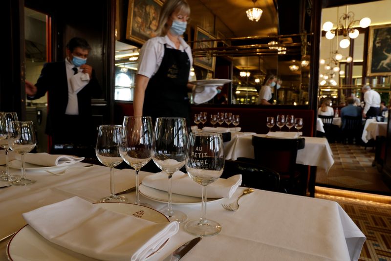 &copy; Reuters. FILE PHOTO: A waiter serves dishes in a dining room at Au Petit Riche restaurant in Paris as cafes, bars and restaurants reopen indoor dining rooms with a fitted gauge and health protocol after closing down for months amid the coronavirus disease (COVID-1