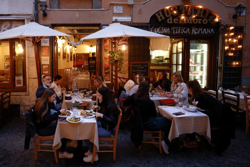 © Reuters. FILE PHOTO: People eat at a restaurant, as much of the country becomes a 'yellow zone', easing coronavirus disease (COVID-19) restrictions and allowing bars and restaurants to serve clients at outdoor tables, in Rome, Italy, April 26, 2021. REUTERS/Guglielmo Mangiapane