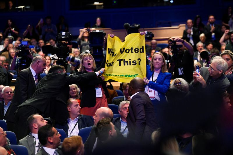 &copy; Reuters. People hold up a sign in protest during British Prime Minister Liz Truss's speech, during Britain's Conservative Party's annual conference in Birmingham, Britain, October 5, 2022. REUTERS/Toby Melville