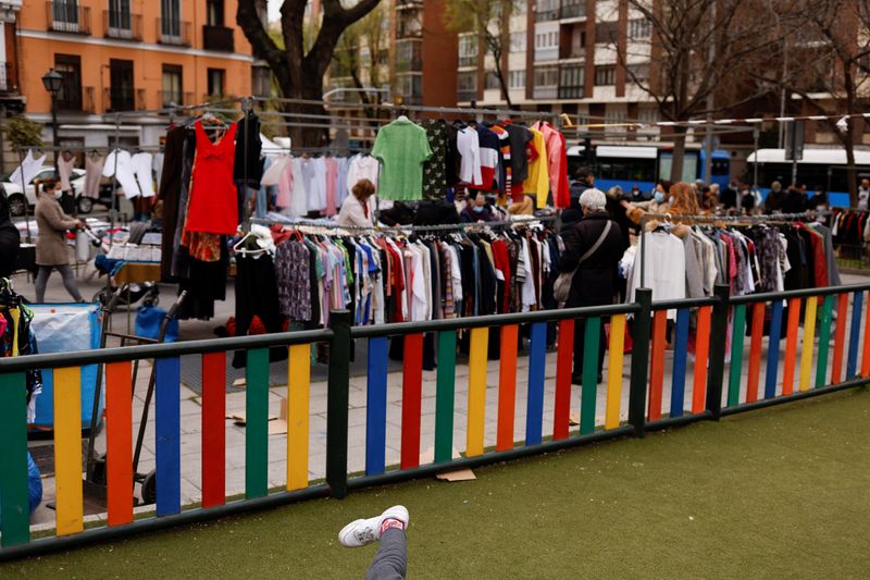 © Reuters. A child plays at a playground as people shop at a street market in Madrid, Spain, April 5, 2022. REUTERS/Susana Vera