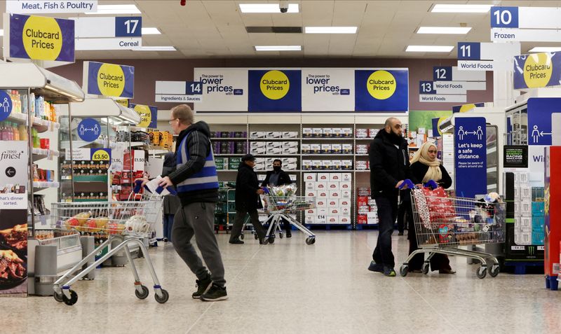 © Reuters. FILE PHOTO: Shoppers walk next to the clubcard price branding inside a branch of a Tesco Extra Supermarket in London, Britain, February 10, 2022. Picture taken February 10, 2022. REUTERS/Paul Childs/File Photo