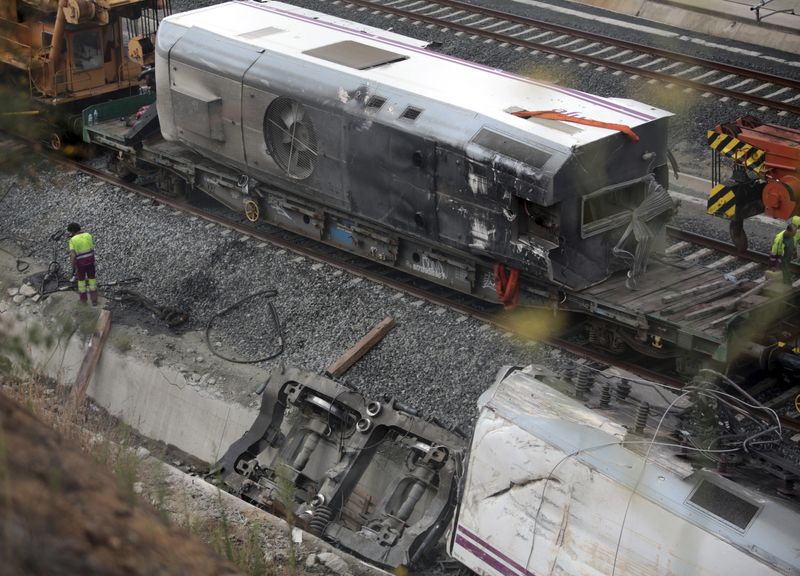 &copy; Reuters. FOTO DE ARCHIVO: Un trabajador junto a la locomotora destrozada (abajo R) en el lugar de un accidente de tren en Santiago de Compostela, noroeste de España, 27 de julio de 2013.  REUTERS/Miguel Vidal 