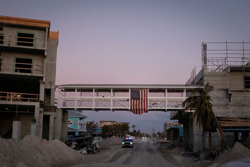 © Reuters. A U.S. flag hangs in a gangway between affected buildings after Hurricane Ian caused widespread destruction in Fort Myers Beach, Florida, U.S., October 4, 2022. REUTERS/Marco Bello