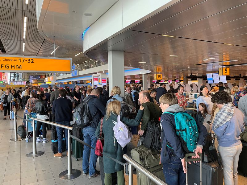 © Reuters. FILE PHOTO: Travellers wait in lines at Amsterdam Schiphol Airport as an unannounced strike of ground staff caused many delays and cancellations, in Amsterdam, Netherlands April 23, 2022. REUTERS/Anthony Deutsch//File Photo