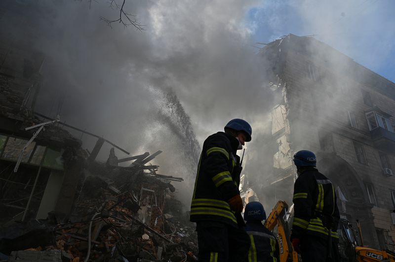 &copy; Reuters. أفراد من خدمات الإنقاذ عند بناية سكنية في اقليم زابوريجيا تعرضت لضربة صاروخية روسية يوم الخميس. تصوير رويترز. 