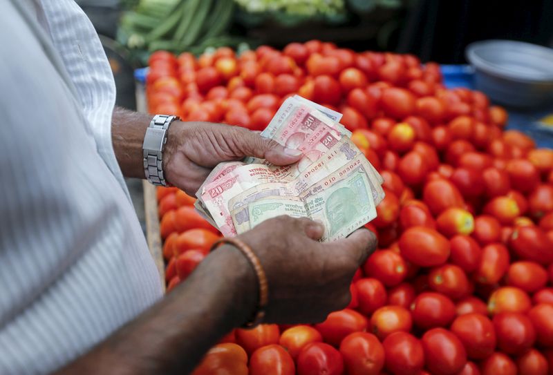 &copy; Reuters. FILE PHOTO: A customer counts money before paying a vegetable vendor at a market in Mumbai, India, June 4, 2015. REUTERS/Shailesh Andrade