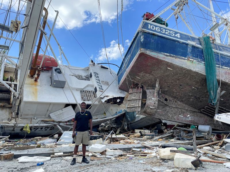 &copy; Reuters. Ricky Moran stands in front of a shrimp boat, captained by him, and two other damaged boats, which were hit by Hurricane Ian at a Fort Myers Beach dock, Florida, U.S., October 5, 2022. REUTERS/Rod Nickel