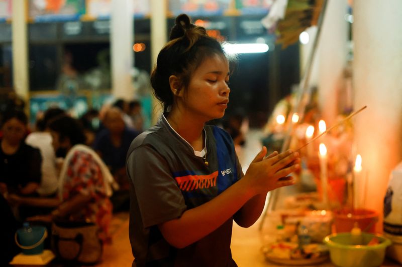 © Reuters. A woman prays at Wat Rat Samakee following a mass shooting in the town of Uthai Sawan, Nong Bua Lam Phu province, Thailand October 7, 2022. REUTERS/Jorge Silva