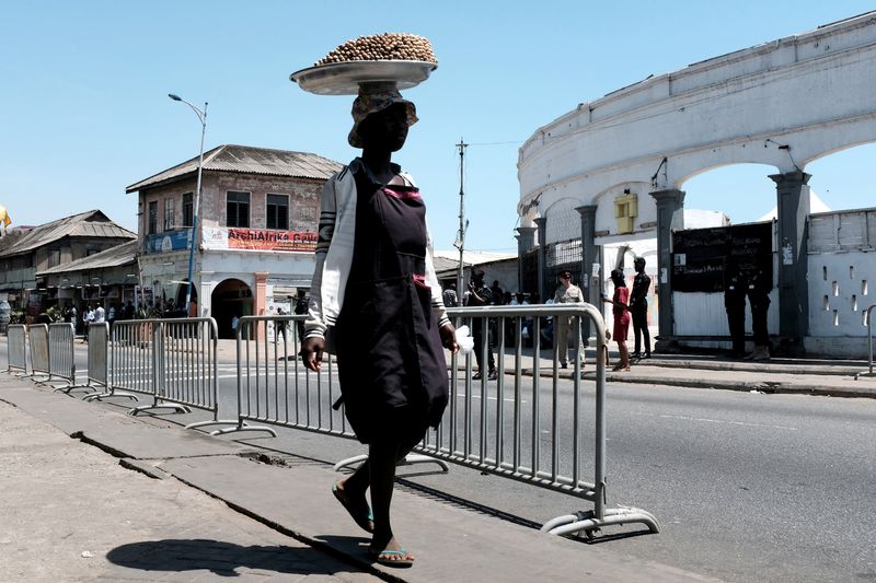 &copy; Reuters. FILE PHOTO: A trader walks past a barricaded street before the arrival of Britain's Prince Charles and Camilla, Duchess of Cornwall, to visit the Jamestown Cafe in old British Accra, Ghana November 3, 2018. REUTERS/Francis Kokoroko/File Photo