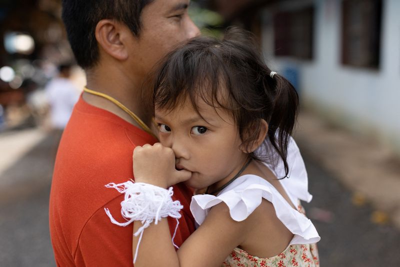 &copy; Reuters. Tawatchai Supolwong holds his 3-year-old daugther Paveenut Supolwong, nicknamed Ammy, who is the only child survivor of the day care centre mass shooting, during a family meeting at their home in Uthai Sawan, Nong Bua Lam Phu province, Thailand, October 9