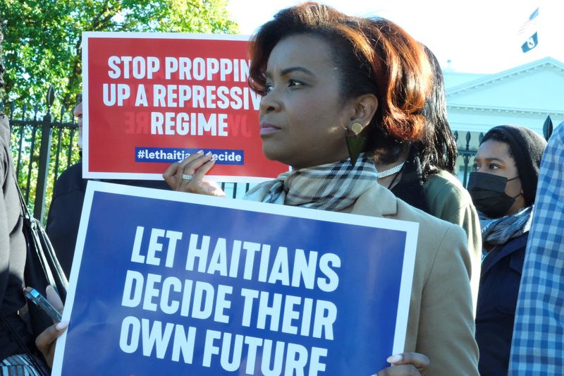 &copy; Reuters. A woman holds a sign at a rally outside the White House asking the Biden administration to stop supporting Haiti's Prime Minister Ariel Henry, in Washington, U.S. October 9, 2022 in this picture obtained by Reuters. Gordon Whitman/via REUTERS  