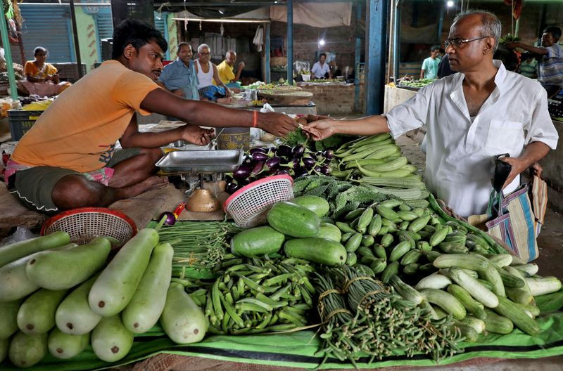 &copy; Reuters. FILE PHOTO: Nikhil Kumar Mondal, 65, a retired school headmaster, buys vegetables from a vendor at a market on the outskirts of Kolkata, India, May 20, 2022. Picture taken May 20, 2022. REUTERS/Rupak De Chowdhuri/File Photo
