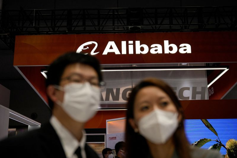 &copy; Reuters. FILE PHOTO: People stand in front of a sign of Alibaba Group during the World Artificial Intelligence Conference, following the coronavirus disease (COVID-19) outbreak, in Shanghai, China, September 1, 2022. REUTERS/Aly Song