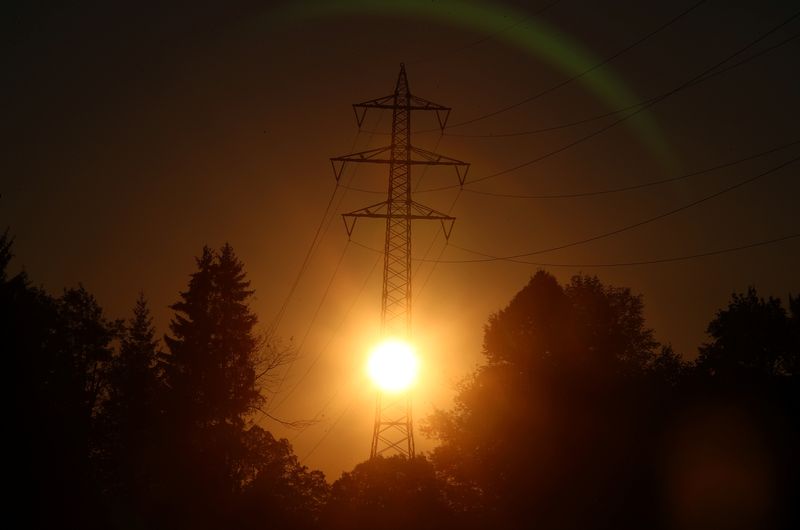 &copy; Reuters. FILE PHOTO: The sun rises behind high-voltage power lines and electricity pylons in Wall near Warngau, Germany, September 28, 2018. REUTERS/Michael Dalder/File Photo