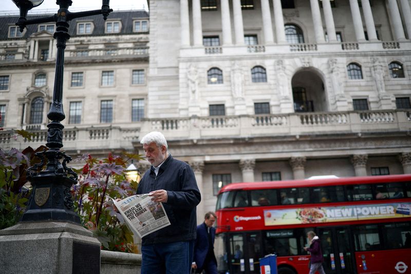 &copy; Reuters. FILE PHOTO: A person reads a newspaper outside the Bank of England in the City of London financial district in London, Britain, October 3, 2022. REUTERS/Henry Nicholls//File Photo