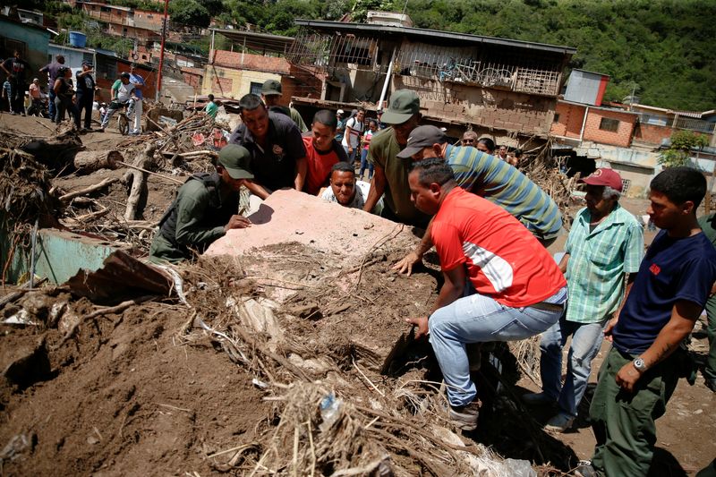 &copy; Reuters. Membros de equipes de resgate e voluntários removem destroços após enchentes em Las Tejerias, na Venezuela. REUTERS/Leonardo Fernandez Viloria