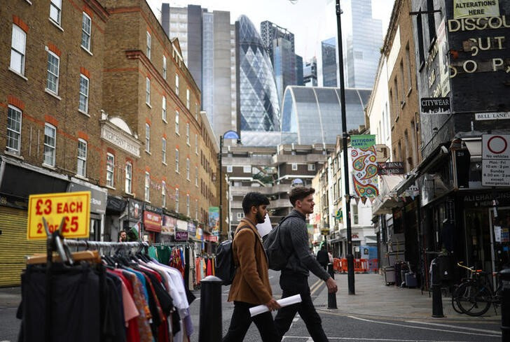 © Reuters. People walk through the Petticoat Lane Market, with the City of London financial district seen in the distance, in London, Britain, October 3, 2022. REUTERS/Henry Nicholls