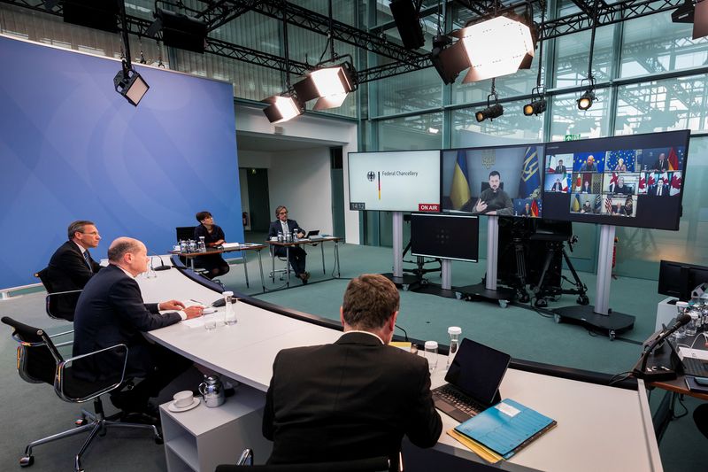&copy; Reuters. الرئيس الأوكراني فولوديمير زيلينسكي يظهر على شاشة بينما يحضر المستشار الألماني أولاف شولتس اجتماعا عن بعد لزعماء مجموعة السبع في برلين يوم