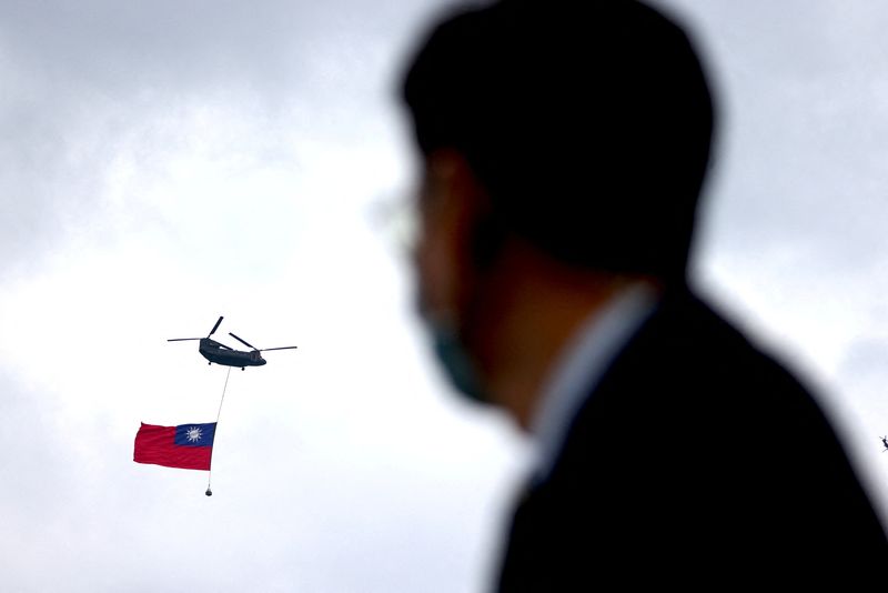© Reuters. A helicopter carrying Taiwan's flag flies by Taipei during the National Day celebrations in front of the Presidential Office in Taipei, Taiwan October 10, 2022. REUTERS/Ann Wang