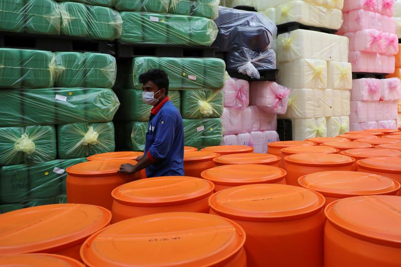 &copy; Reuters. FILE PHOTO: A foreign worker works at a plastic containers factory during an enhanced lockdown, amid the coronavirus disease (COVID-19) outbreak, in Pulau Indah, Malaysia July 8, 2021. REUTERS/Lim Huey Teng