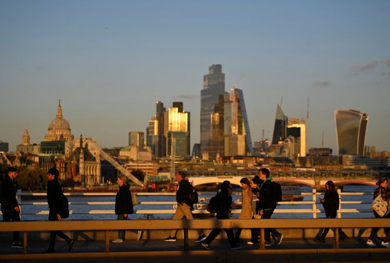 &copy; Reuters. People cross Waterloo Bridge during the evening rush-hour with skyscrapers of the City of London financial district seen behind in London, Britain, October 10, 2022.  REUTERS/Toby Melville